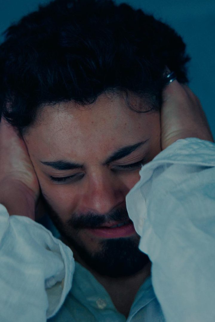 Un ragazzo con le mani sulle orecchie