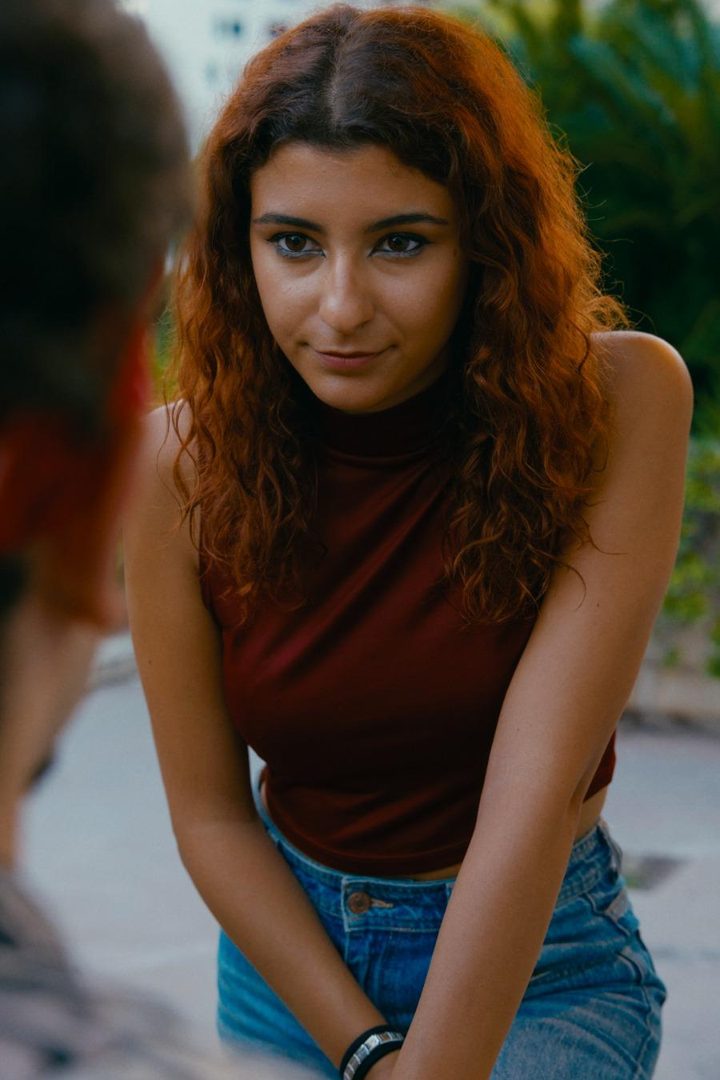 Una ragazza dai capelli rossi lo guarda
