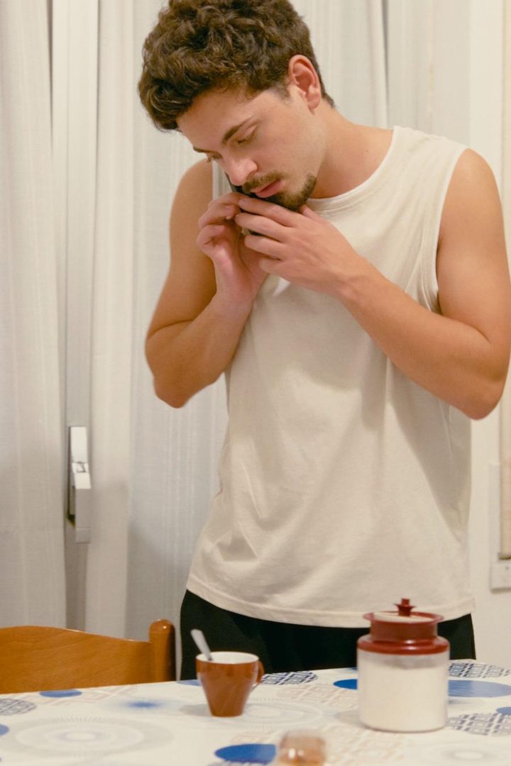 Un ragazzo al telefono in cucina
